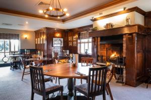 a dining room with a table and a fireplace at Two Rivers Lodge by Marston’s Inns in Chepstow