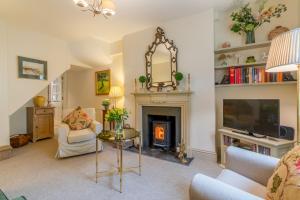 a living room with a fireplace and a tv at New Church Cottage in Tetbury
