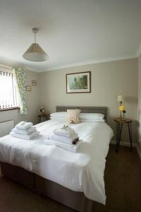 a bedroom with a white bed with towels on it at Goitre Bach Cottage in Aberaeron