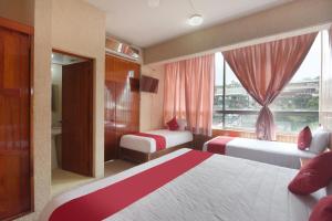 a hotel room with two beds and a window at OYO Hotel Totonacapan, Papantla in Papantla de Olarte