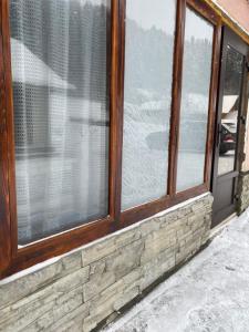 una ventana de una casa con nieve en el suelo en Відпочинок у Карпатах en Volovets