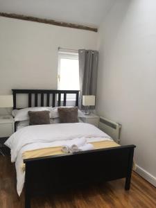 1 dormitorio con 1 cama con sábanas blancas y ventana en The Thornham, en Leicester