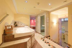 a large bathroom with a tub and a shower at Hotel Enzian Paznaun in See