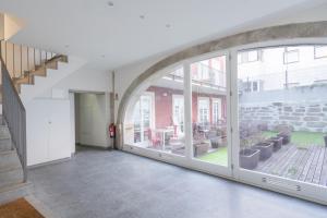 an empty hallway with large windows and a staircase at Habitatio - Foz by LuxiStay in Porto