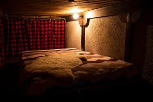 a teddy bear laying on a bed in a dark room at Hunter's Lodge in (( Šarlote ))