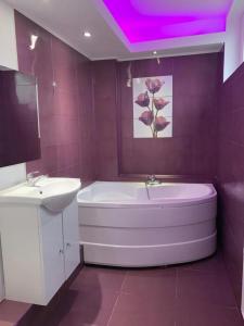 y baño con bañera blanca y lavamanos. en Karra Hotels, en Voluntari