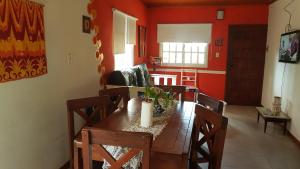 a dining room with red walls and a table and chairs at Cabañas La Polaca 1 in Santa Clara del Mar
