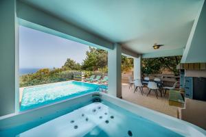 a house with a swimming pool and a patio at Mikra Anogia Villas in Rethymno