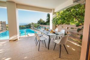 a patio with a table and chairs and a pool at Mikra Anogia Villas in Rethymno Town