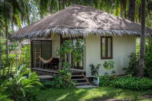 a small house with a thatched roof at Baan Manali Resort in Thongsala