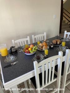 a table with a bunch of fruit on it at Residencial Dona Dina - Mestre Naro in Bombinhas