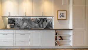 een keuken met witte kasten en een spoelbak bij HvileStay Sopot - prywatne miejsce parkingowe in Sopot +20 foto's