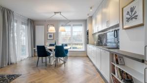 een keuken met een tafel en stoelen en een eetkamer bij HvileStay Sopot - prywatne miejsce parkingowe in Sopot