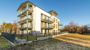 een appartementengebouw met een hek ervoor bij HvileStay Sopot - prywatne miejsce parkingowe in Sopot