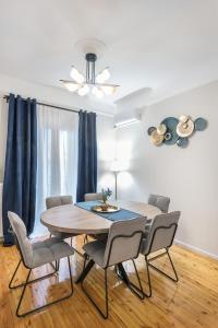 a dining room with a wooden table and chairs at Porto Sea View Apartments - Kypriou in Thessaloniki