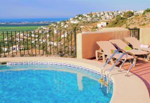 una piscina con sillas y vistas al océano en Villa del Mar, en Monte Pego