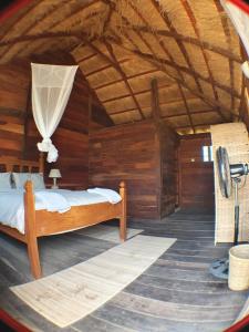 a bedroom with a bed in a wooden room at Bees Mouth Gambia in Sanyang