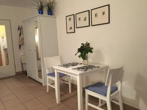 a dining room with a white table and chairs at Ostseeresidenz - App 08 Meeresrauschen in Zingst