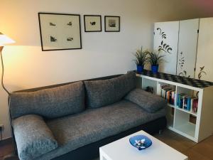 a living room with a couch and a book shelf at Ostseeresidenz - App 08 Meeresrauschen in Zingst