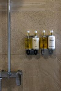 um grupo de quatro garrafas numa prateleira numa casa de banho em Marina Yacht Hotel Sochi em Sochi
