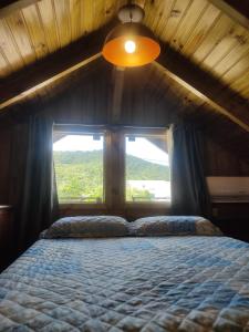 Schlafzimmer mit einem großen Bett und einem Fenster in der Unterkunft Chalés Costa Esmeralda, Bombinhas in Bombinhas
