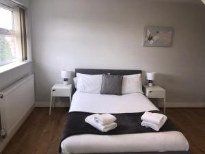 a bedroom with a bed with two towels on it at 2nd Floor Town Centre Apt with FREE Parking in Loughborough