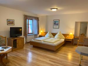 a bedroom with a bed and a flat screen tv at Hotel Lobmeyer in Roding