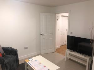 ein Wohnzimmer mit einem Flachbild-TV und einem Sofa in der Unterkunft 2nd Floor Town Centre Apt with FREE Parking in Loughborough