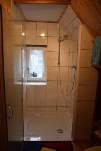 baño con ducha y bañera con ventana en Ferienhaus Zur kleinen Kneipe, en Fladungen 20 fotos más