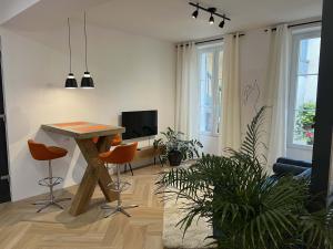 een woonkamer met een houten tafel en stoelen bij Bel appartement au centre du vieux Joigny in Joigny