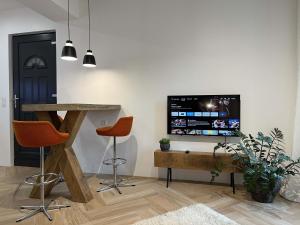 ein Wohnzimmer mit einem Flachbild-TV an der Wand in der Unterkunft Bel appartement au centre du vieux Joigny in Joigny