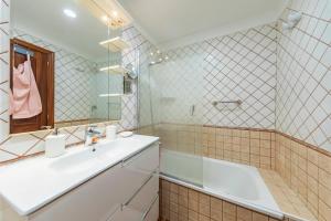 a bathroom with a sink and a tub and a mirror at MEDANO4YOU The Rosuca Holiday Home in El Médano