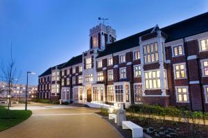 a large brick building with a clock tower at 2nd Floor Town Centre Apt with FREE Parking in Loughborough