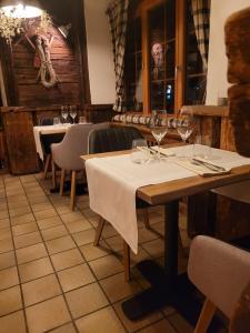 Pension de la Poste في زينل: طاولة في مطعم مع كؤوس النبيذ عليه