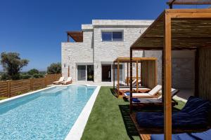 una piscina con sillas y una casa en Mandana Villa - With Private Pool & Jacuzzi en Agios Dimitrios
