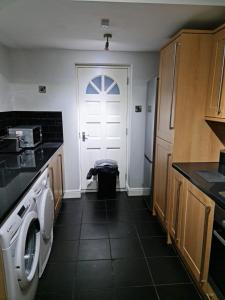 a kitchen with a washing machine and a white door at 24 Dryden Road - Beautiful 2 bed in Longley