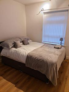 a bedroom with a large bed with a window at 24 Dryden Road - Beautiful 2 bed in Longley