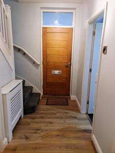 a hallway with a wooden door and stairs at 24 Dryden Road - Beautiful 2 bed in Longley