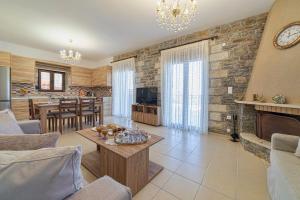 a living room with a fireplace and a dining room at Asfendamos Villas in Zonianá
