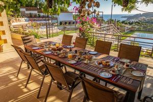 una mesa de madera con comida en la parte superior de un patio en Villa Staras - With Private Heated Pool & Jacuzzi en Gerani