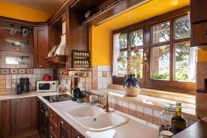 cocina con fregadero y ventana en Villa Staras - With Private Heated Pool & Jacuzzi en Gerani