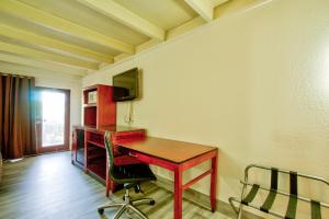 Zimmer mit einem Schreibtisch, einem TV und einem Stuhl in der Unterkunft Clearwater Hotel in Clearwater