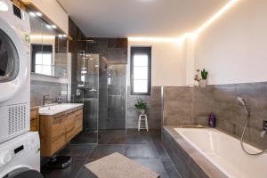 een badkamer met een bad, een douche en een wastafel bij Ferienhaus Donautal in Sigmaringen