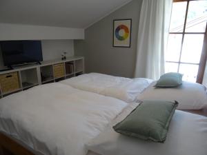 a bedroom with two white beds and a television at Ferienwohnung Herb in Bad Reichenhall