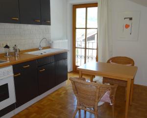 a kitchen with a sink and a table with chairs at Ferienwohnung Herb in Bad Reichenhall