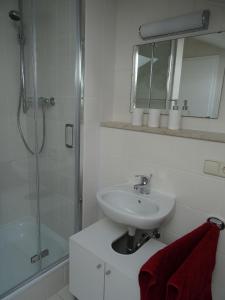 a white bathroom with a sink and a shower at Ferienwohnung Herb in Bad Reichenhall