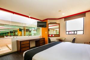 una camera con un grande letto e una TV di Capital O Hotel Casa Blanca, Morelia a Morelia
