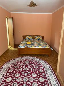 Schlafzimmer mit einem Bett und einem roten Teppich in der Unterkunft 2-х комнатная Ауезова in Öskemen