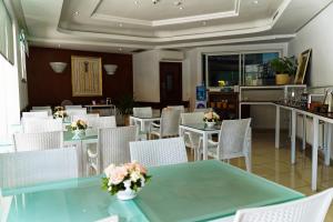 a restaurant with tables and chairs with flowers on them at Hotel Khella in Hammamet