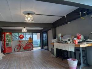 a kitchen with a counter and a red bike on the wall at บ้านศรีมีทรัพย์ เขาค้อ in Khao Kho